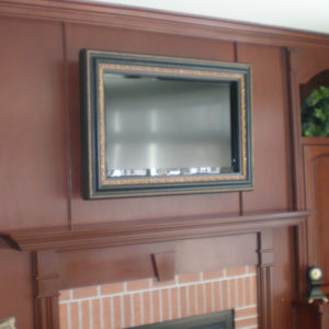 TV in hidden frame over fireplace