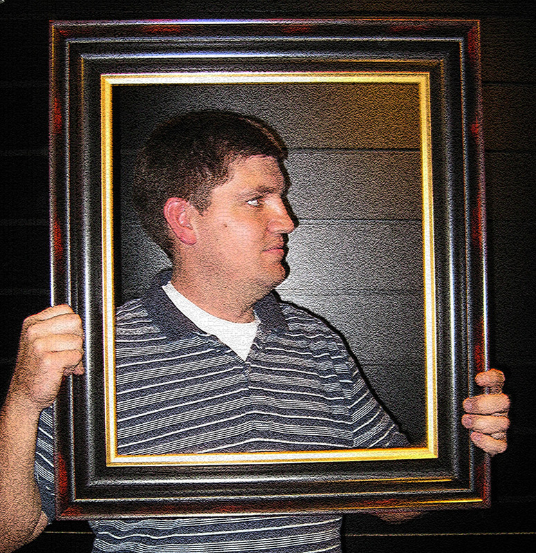 man holding up empty frame