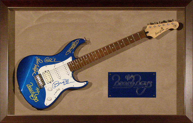 a signed beach boys guitar that's been framed