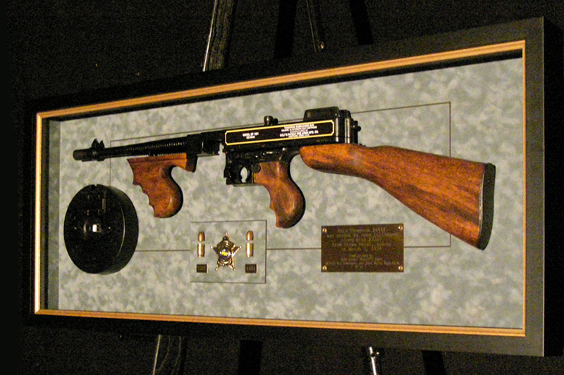 framed rifle and badge