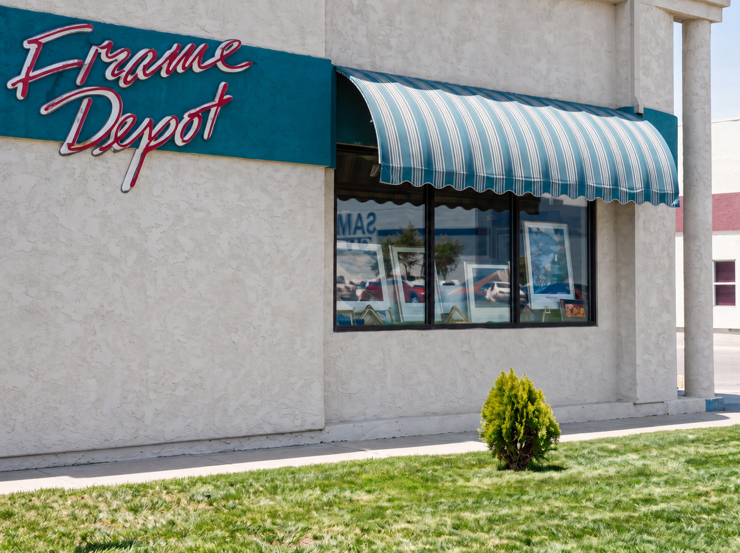 A view of the current location with the Frame Depot neon sign.